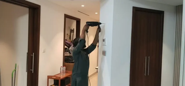 Handyman in Downtown Dubai 20 Handyman drilling in wall to hang a frame